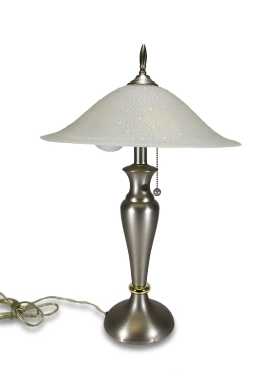 1980s Art Deco Style Frosted Glass & Metal Lamp: 1980s Art Deco-style table lamp with brushed metal body, flared base, and domed frosted glass shade with pebble texture. Dimensions: 23 X 15 X 15 in. Condition: Good overall condition having normal