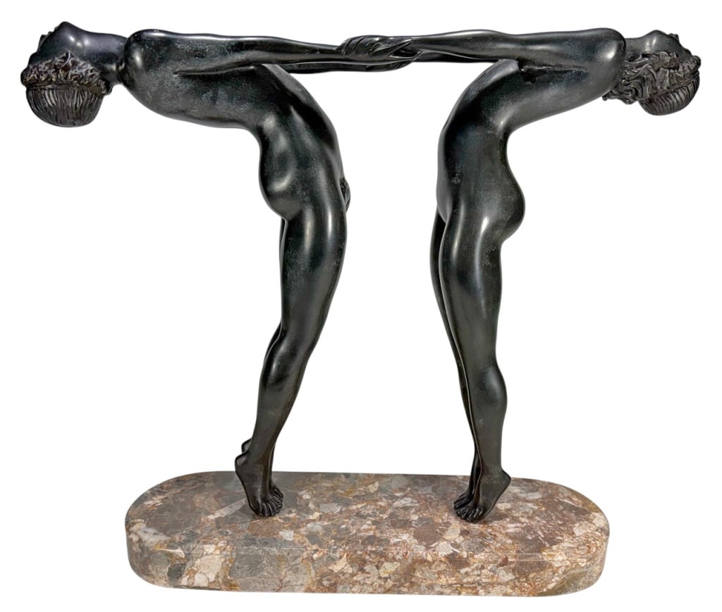 Bacchante Bronze after Maud S Jewett (1873-1953): Bronze figural composition after Maude Sherwood Jewett (American, 1873-1953). The sculpture depicts two nude figures standing in mirrored poses with their arms intertwined, evoking the rhythm and grac