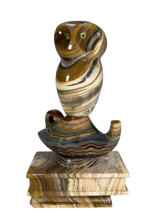 Large Carved Banded Onyx Owl Sculpture: Hand-carved onyx owl sculpture on a tiered base, featuring polished golden, cream, and brown banding. Dimensions: 15.5 X 8.25 X 6 in. Condition: Good overall condition having normal surface wear. D