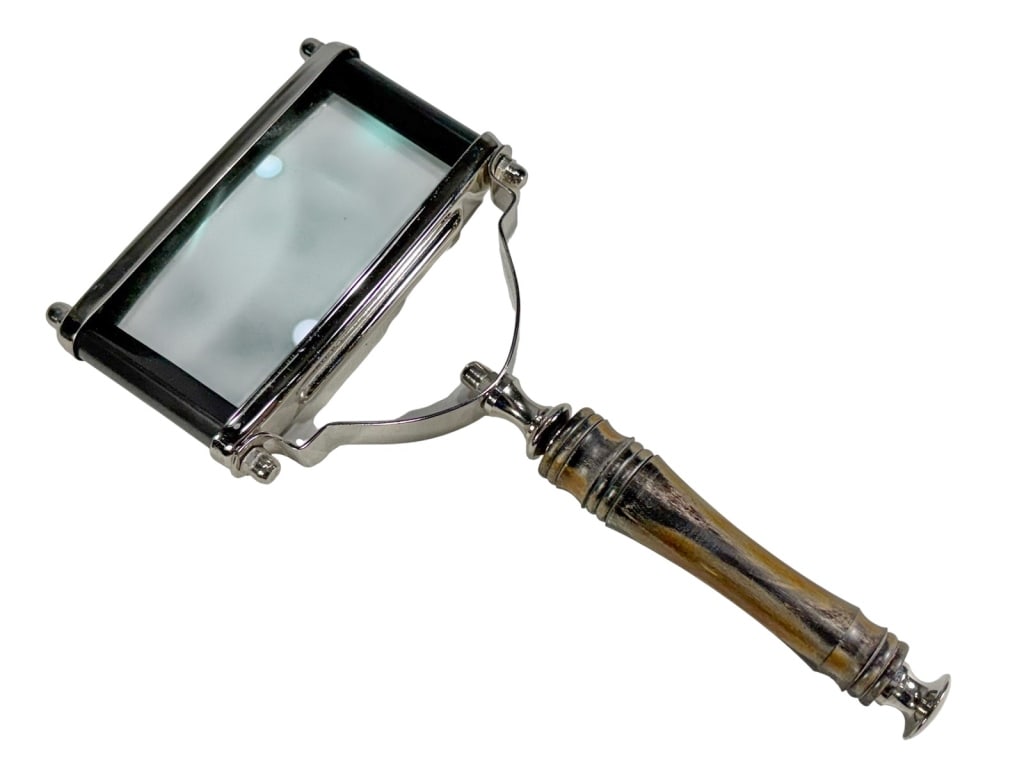 VTG Rectangular Metal & Horn Magnifying Glass: Rectangular magnifying glass with silver-tone frame and curved horn handle, featuring turned details and flared finial.Dimensions: 10 X 5 X 1 in. Condition: Good overall condition having normal su