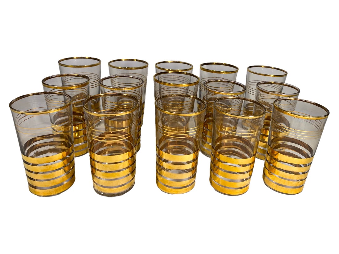 Mid Century Gilt Water & Wine Glasses 15pc LOT: Fifteen mid-century clear glass tumblers decorated with horizontal gilt bands and rims, elegant for water or wine service. The largest measures approximately 5 inches tall by 2.75 inches wide by 2.75