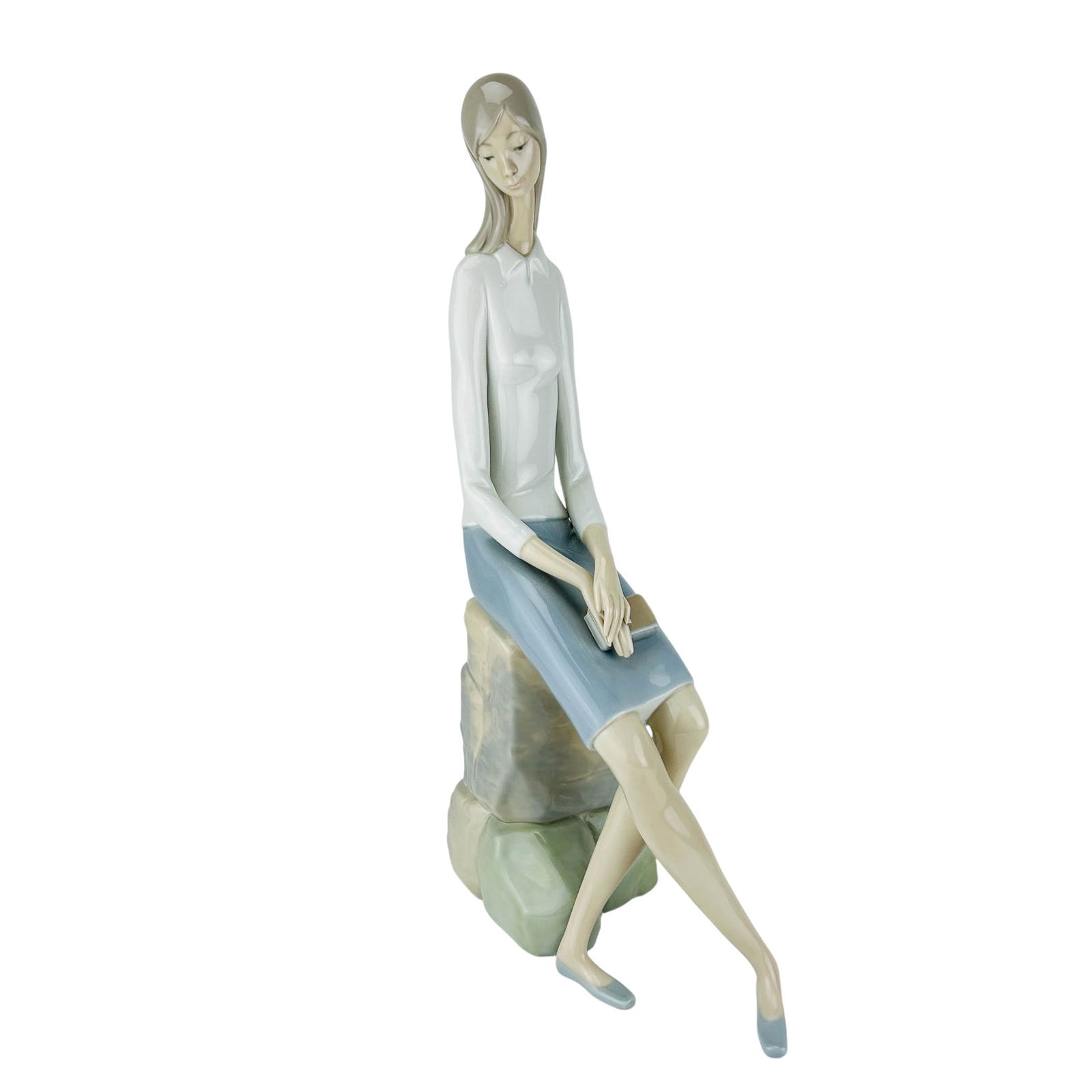 Lladro Spain Girl Student #4518 Porcelain Figurine: Lladro Spanish Girl Student model number 4518 hand painted porcelain figurine. Sculptor Fulgencio Garcia. Produced between 1969-1978. Depicts a young woman seated on a rock, holding a book in her lap,