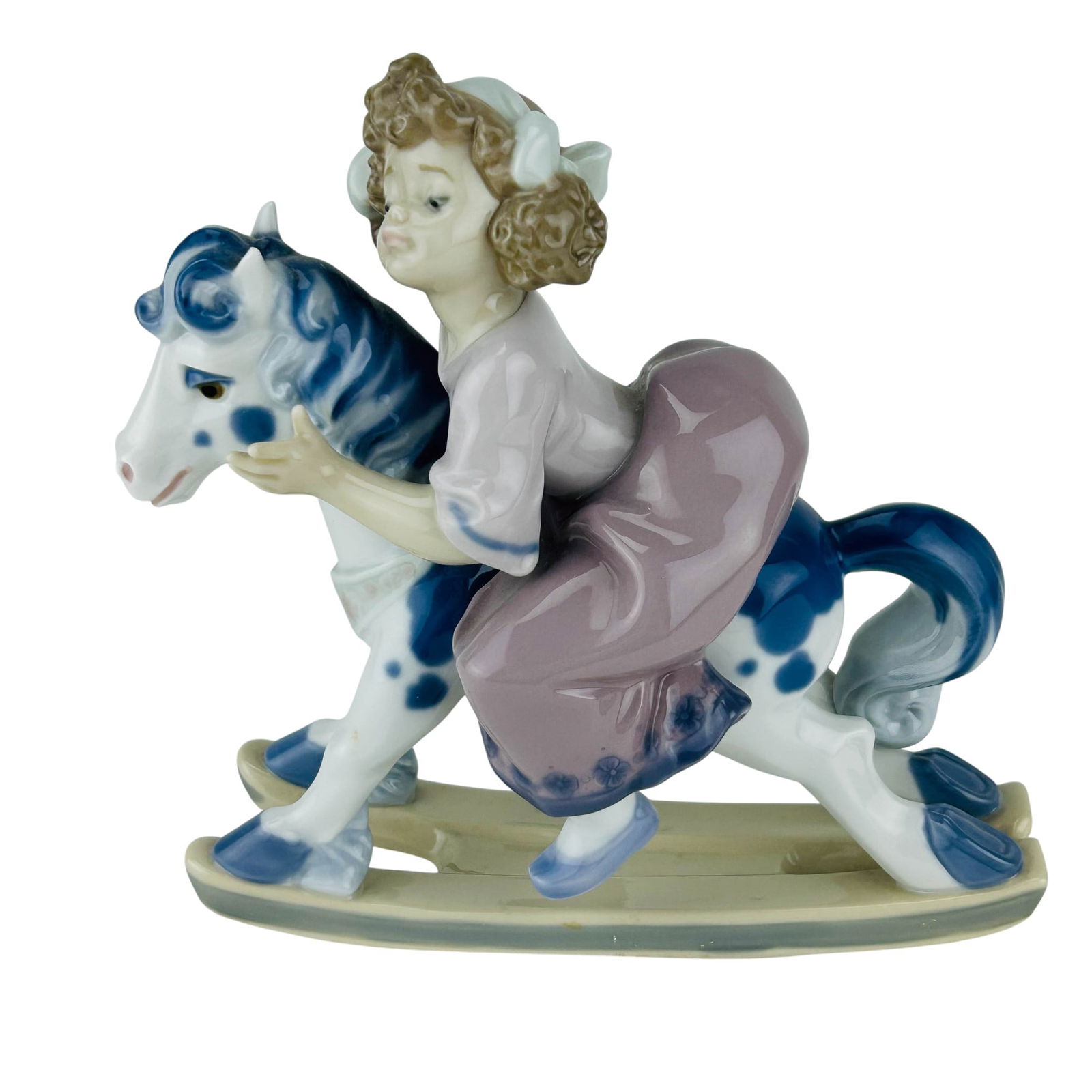Lladro Faithful Steed #5769 Porcelain Figurine: Lladro Spanish Faithful Steed model number 5769 hand painted porcelain figurine. Sculptor Francisco Polope. Produced between 1991-1994. Features a young girl riding her toy rocking horse. Stamped with