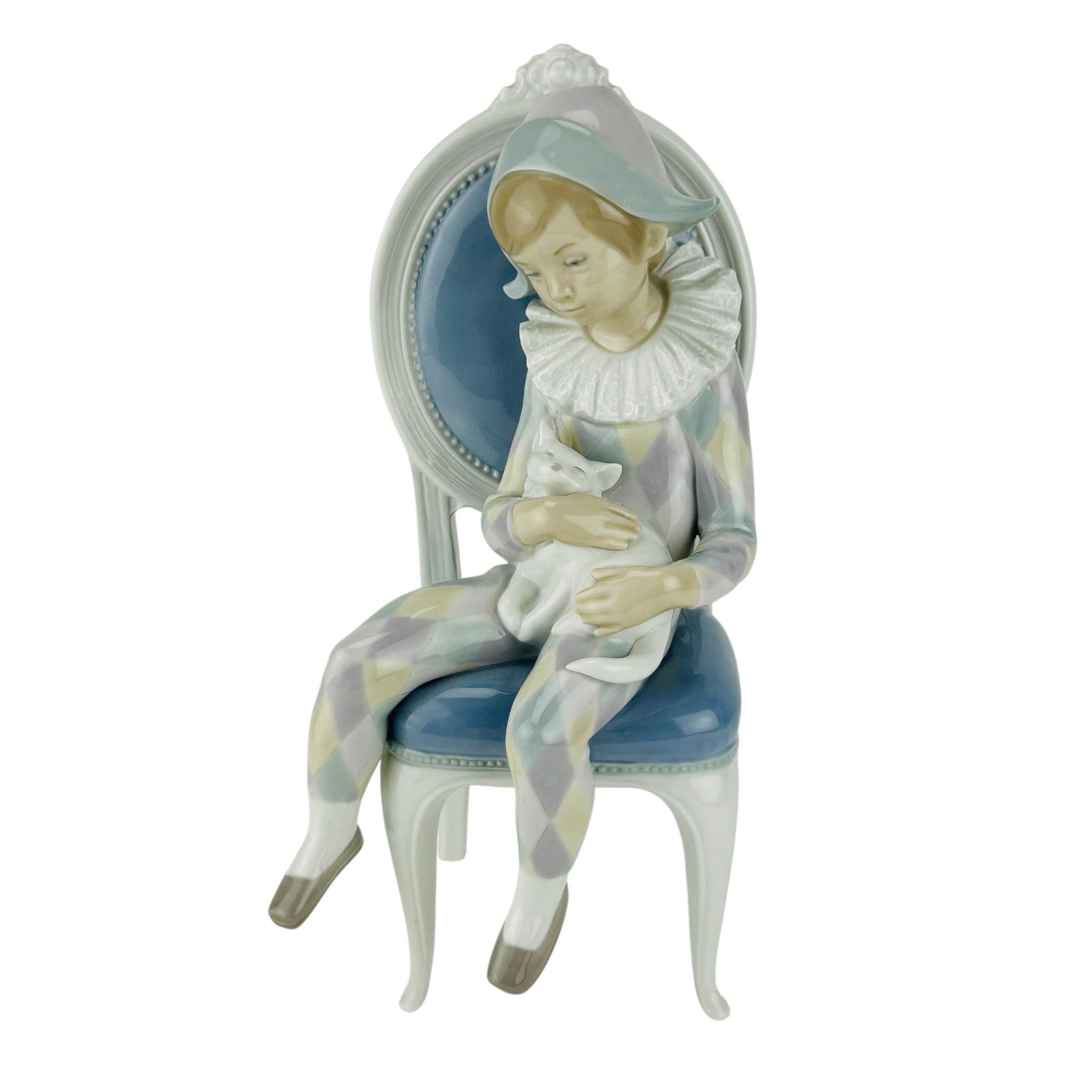 Lladro Young Harlequin # 1229 Porcelain Figurine: Lladro Spanish Young Harlequin porcelain figurine. Model number 1229. Sculptor Fulgencio Garcia. Produced from 1972-1999. Depicts a seated child in pastel harlequin attire holding a white cat, resting