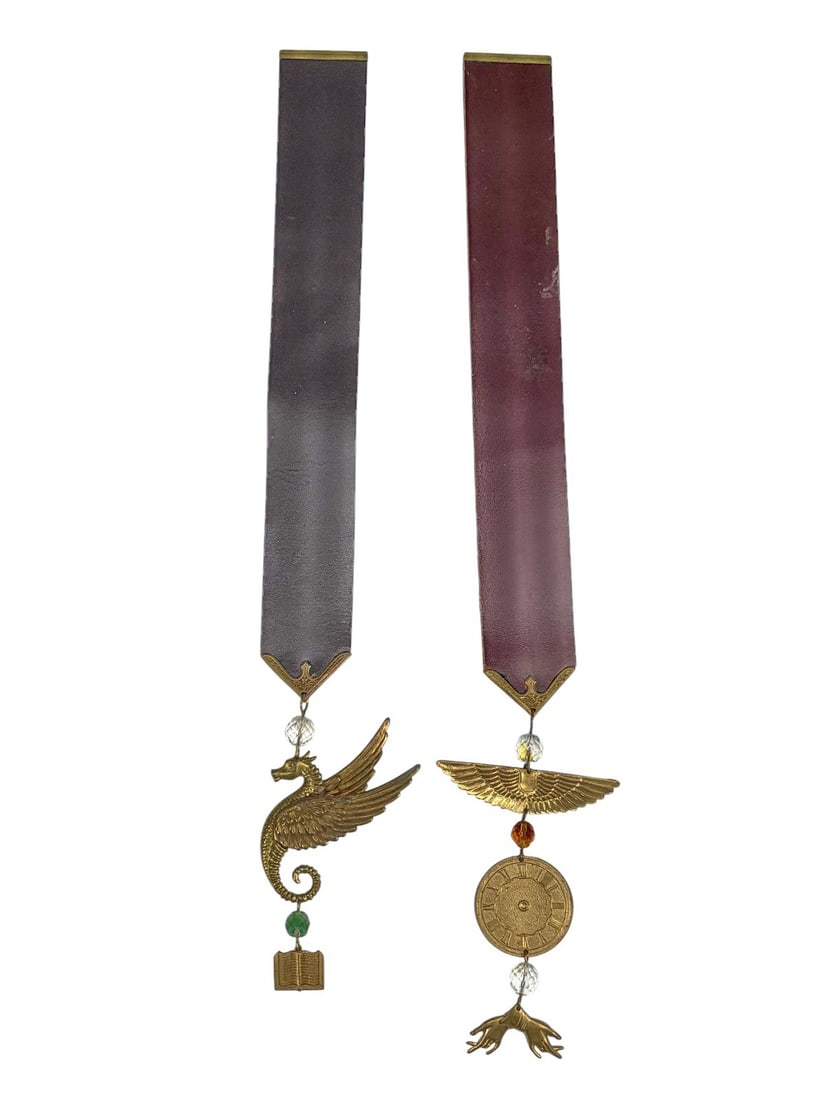 Masonic Handcrafted Ceremonial Decorations 2pc LOT: Pair of handcrafted Masonic ceremonial decorations with leather ribbons, brass trim, and symbolic pendants featuring winged motifs, beads, and crystal accents. The largest measures approximately 14.5