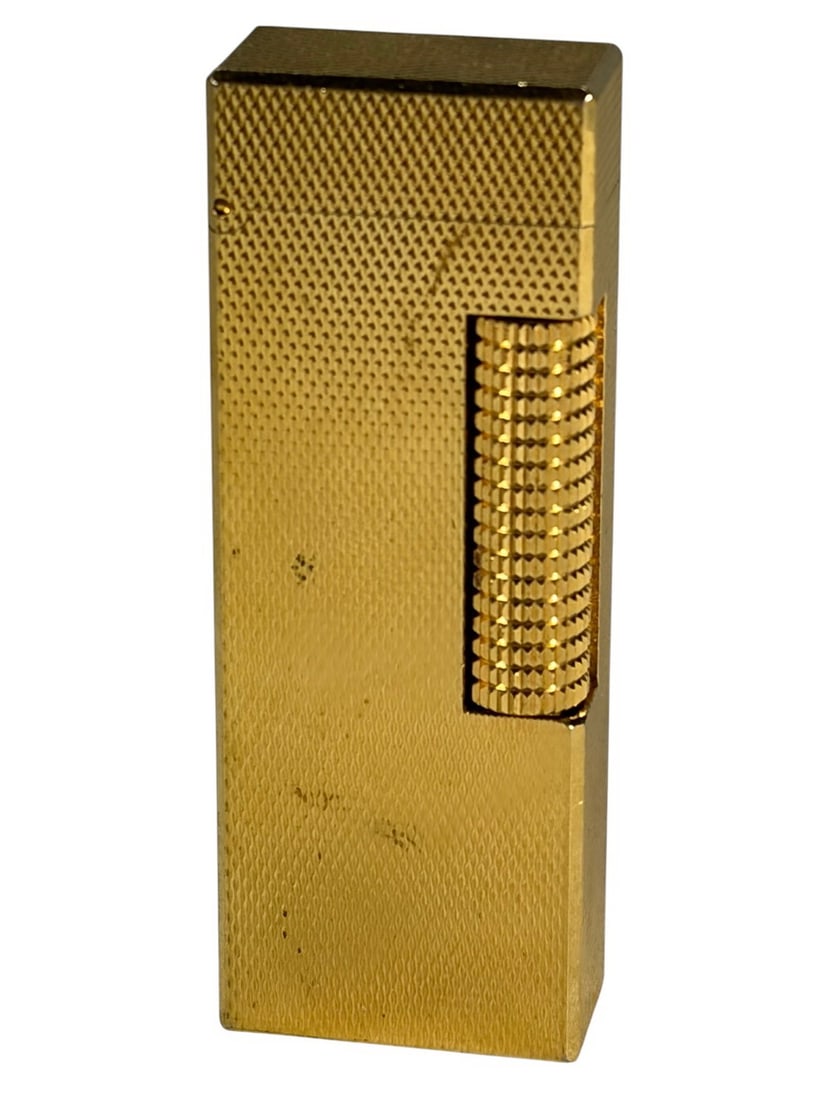 Dunhill Rollagas Swiss Gold Plated Lighter: Classic gold-plated Dunhill Rollagas lighter with textured geometric pattern, flip-top design, side roller, and marked 'Made in Switzerland' and 'US RE 24163 Patented' on the base.Dimensions: 2.5 X 1