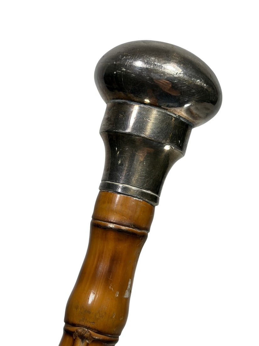 Mappin & Webb English Silver & Bamboo Cane: English bamboo walking cane by Mappin & Webb, with a silver knob handle and matching ferrule, natural bamboo shaft with visible nodes, and silver hallmarks present.Dimensions: 32.5 X 1.5 X 1.5 in. Con