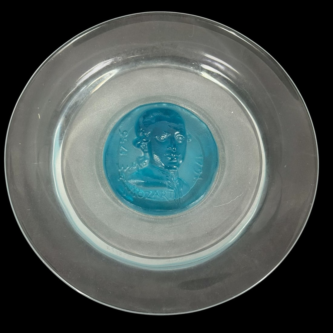 Daum French Limited Edition Mozart Art Glass Plate: Daum French limited edition art glass plate, commemorating composer Wolfgang Amadeus Mozart. The centerpiece of the plate features a deep turquoise pate de verre raised portrait of Mozart in profile.