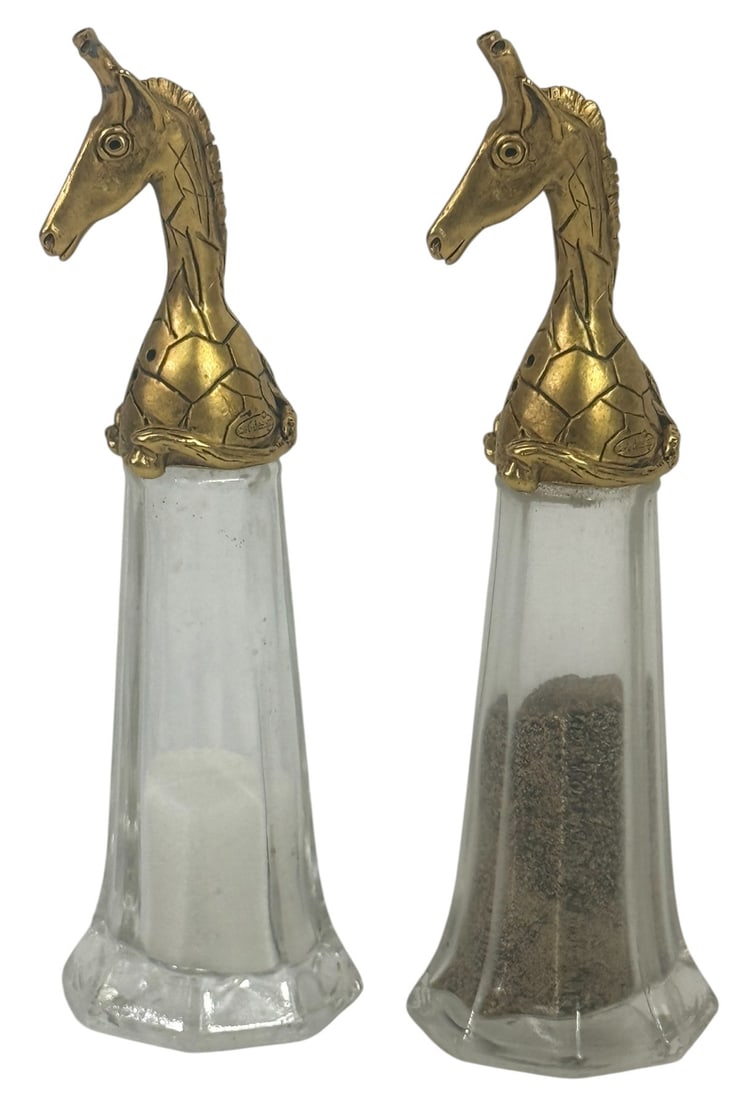Pair of Giraffe Motif Salt & Pepper Shakers: Whimsical pair of salt and pepper shakers, featuring glass bodies topped with sculptural brass giraffe heads. The giraffes are highly detailed, with etched textures suggesting their characteristic pat