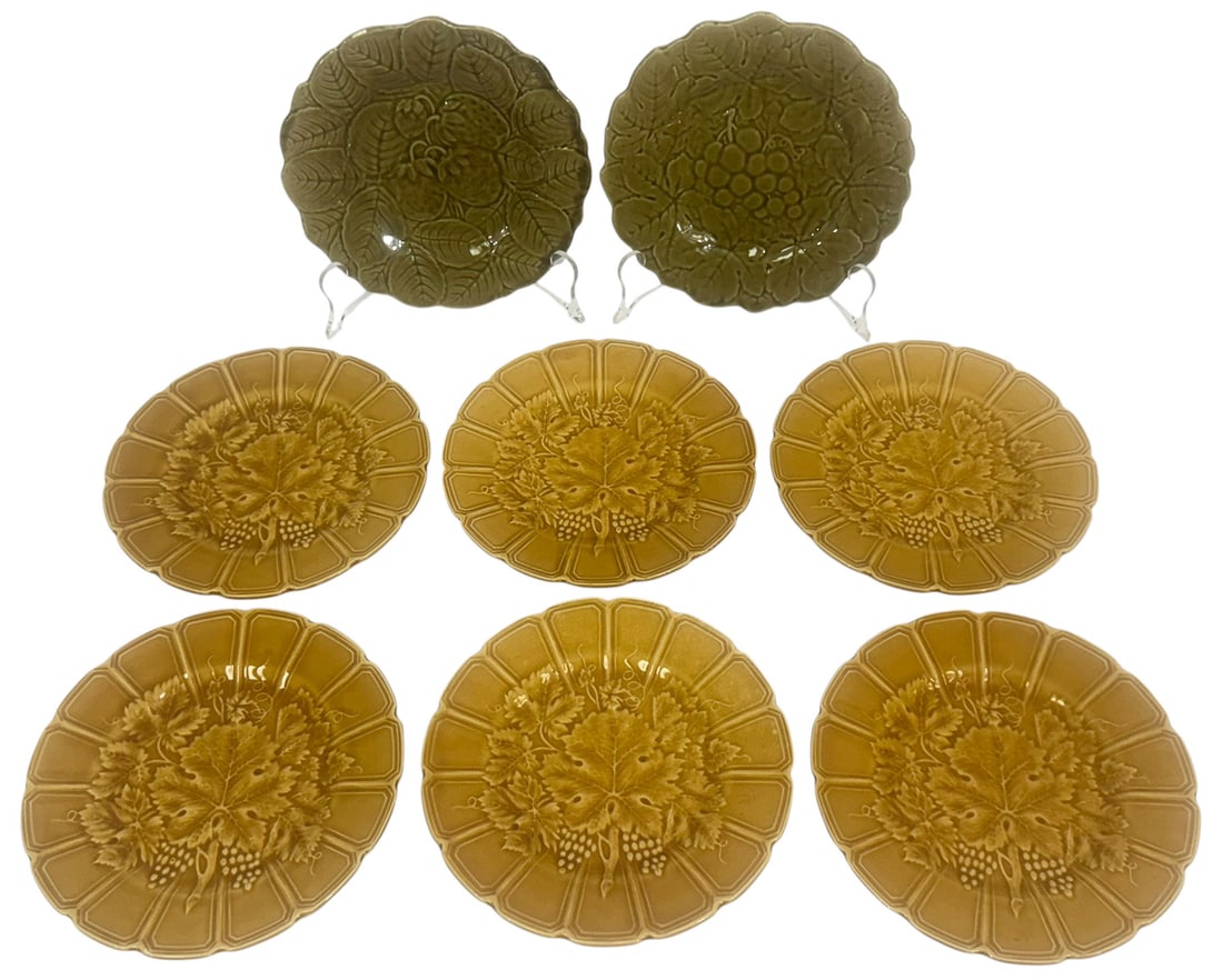 Sarreguemines French Majolica Plates 8pc SET: Set of eight French majolica plates by Sarreguemines, featuring richly molded botanical and fruit motifs. Six of the plates are in a mustard glaze with raised grapevine designs, while two are