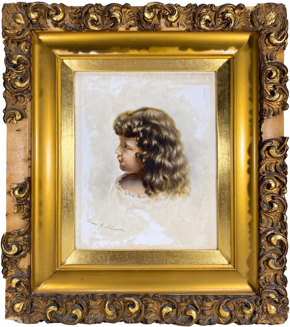 Signed Laura Schneider Painting over Porcelain: Painted porcelain portrait of a young child in profile by Laura J. Schneider, executed with delicate shading. Signed to the lower left. Set in an ornate giltwood frame with carved scrolling