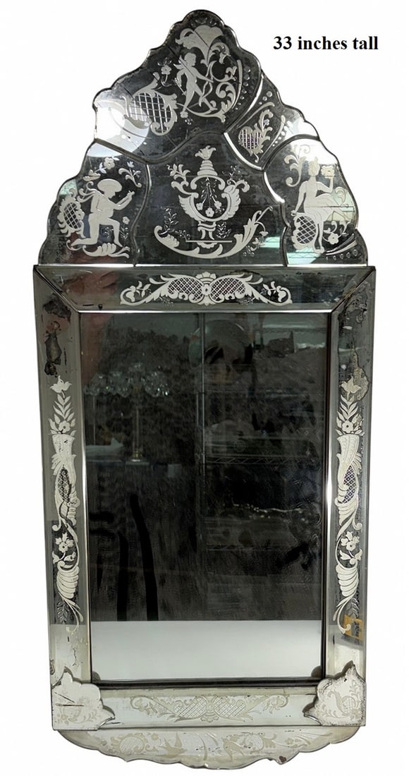 VTG Venetian-Style Beveled Engraved Glass Mirror: Vintage Italian Venetian-style wall mirror with beveled panels and reverse-etched glass decoration featuring figural and floral motifs, mounted to a wood backing.Dimensions: 33 X 14.75 X 0.75 in. Cond