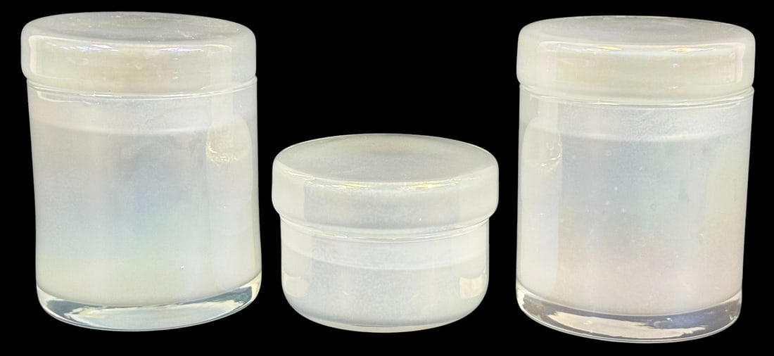 Vintage Iridescent Art Glass Covered Boxes 3pc SET: Lot of three vintage iridescent art glass covered boxes. Each features a cylindrical form with flat, snug-fitting lids. The glass has a soft, ethereal glow with a milky, opalescent finish and subtle