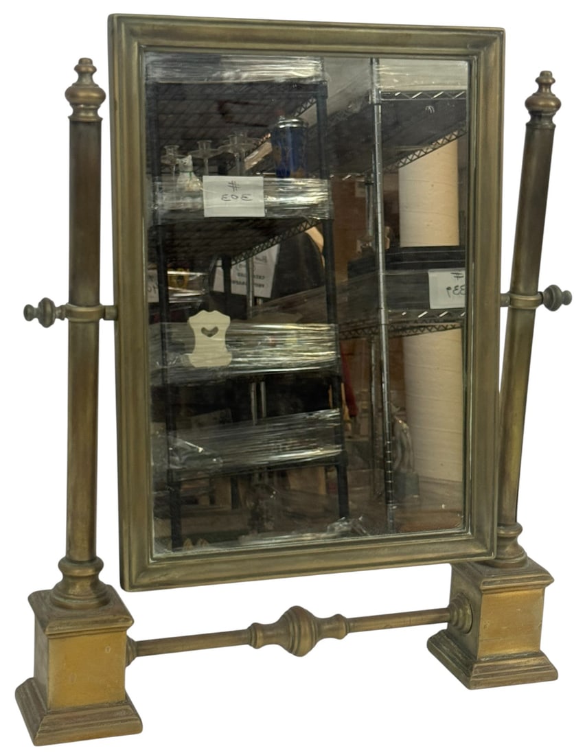 20th C. Deco-Style Brass Adjustable Vanity Mirror: 20th century tabletop vanity mirror with an adjustable tilt mechanism, set within a solid brass frame. The rectangular mirror is supported by two classical column-style side posts mounted on square ba