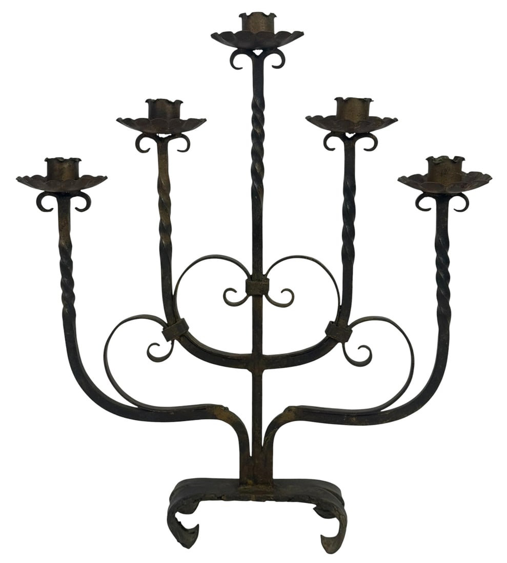 Vintage Wrought Iron Five-Arm Candelabra: Vintage estate hand-forged wrought iron five-arm candelabra. The piece features twisted arms rising from a scrolled body and terminating in scalloped bobeches with cylindrical candle cups. Its scrollw