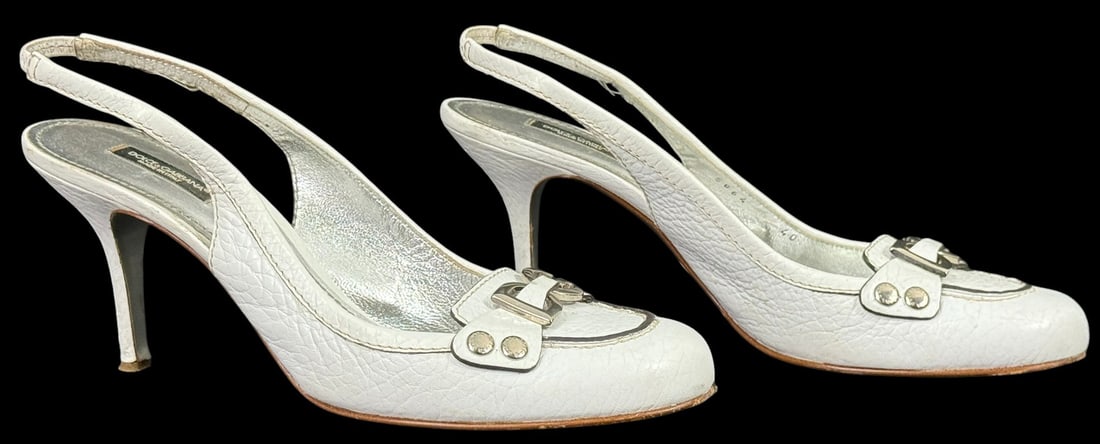 Dolce & Gabbana White Leather Slingback Heels s40: Pair of Dolce & Gabbana Italian-made slingback high heel shoes in textured white leather. These heels feature silver-tone DG logo hardware and rhinestone accents across the vamp, with a metallic silve