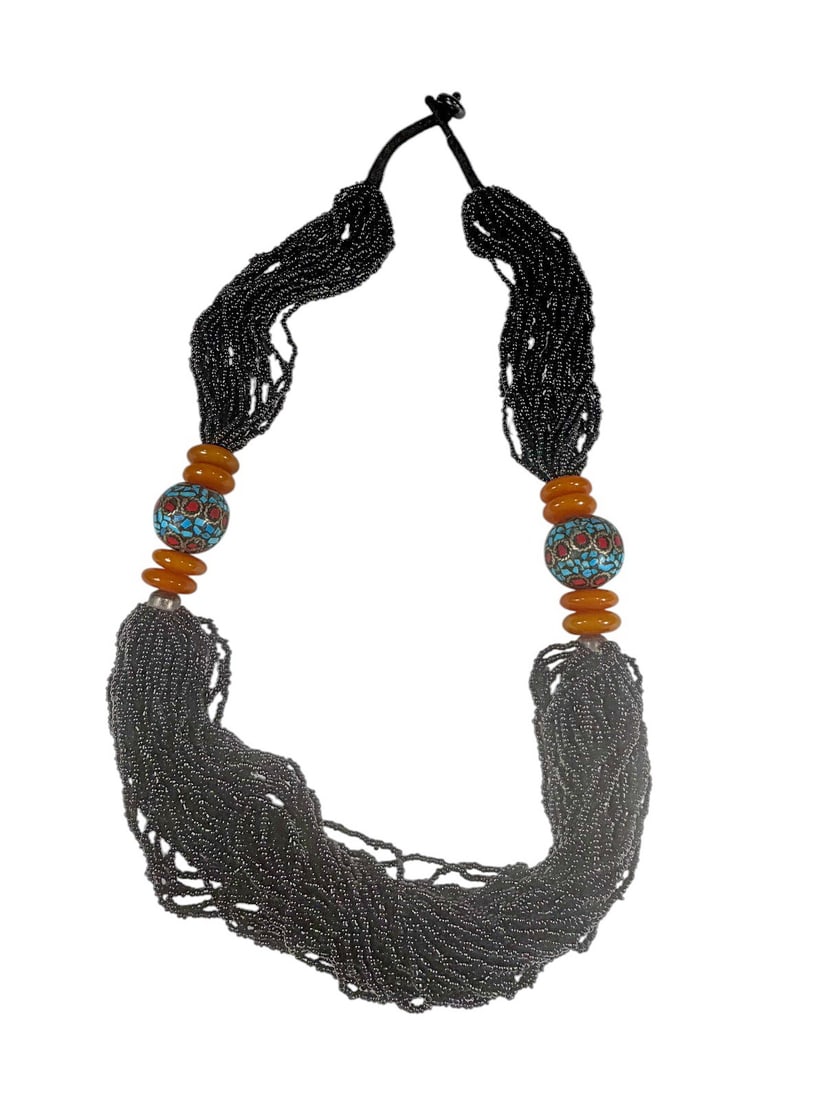 Nepal Multi-Strand Beaded & Turquoise Necklace: Nepal handcrafted multi strand black seed bead necklace with inlaid turquoise and red coral mosaic focal beads and amber tone resin discs. The necklace measures 31.5 inches long and 1 inch