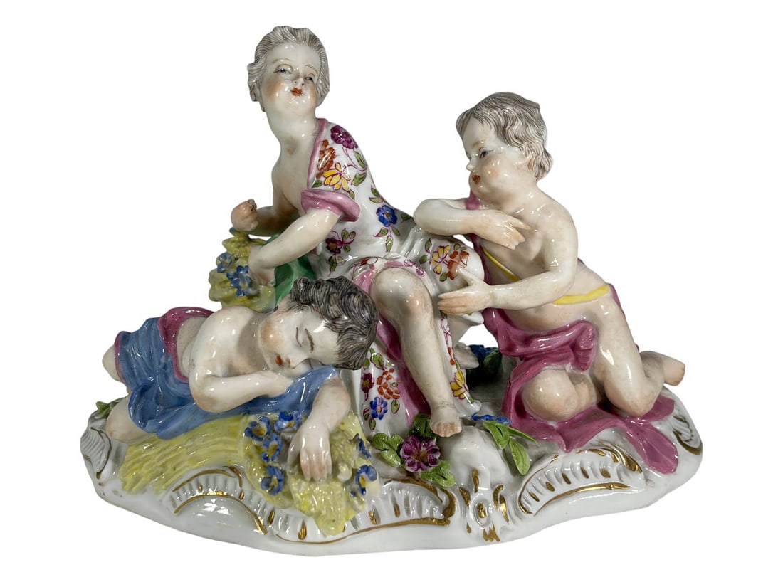 Antique Meissen Cherub European Porcelain Figurine: Antique Meissen German porcelain figural group of a seated woman with cherubs, hand-painted in polychrome with gilt accents. Marked with blue crossed swords to its base.Dimensions: 4 X 6 X 4 in.