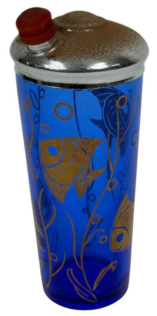 Mid-Century Blue Glass Nautical Cocktail Shaker: Estate mid-century cocktail shaker made of vibrant cobalt blue glass, decorated with a gilt design of tropical fish and underwater plant life. The shaker features a domed chrome-plated metal lid with