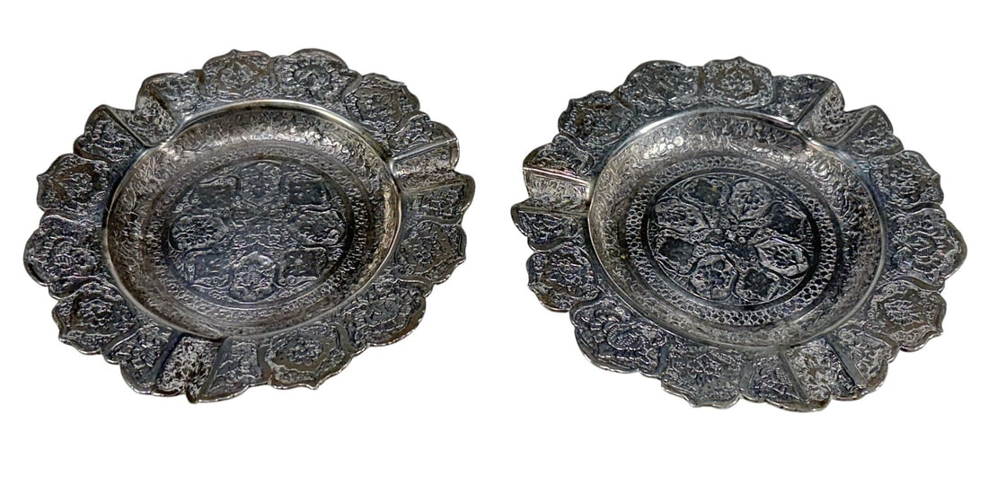 Vintage Persian 875 Silver Ashtrays 2pc LOT: Pair of Persian 875 silver ashtrays with scalloped rims and ornate floral repousse and engraved decoration. Stamped with Persian silver hallmarks, likely indicating .875 or .900 silver. Each piece mea