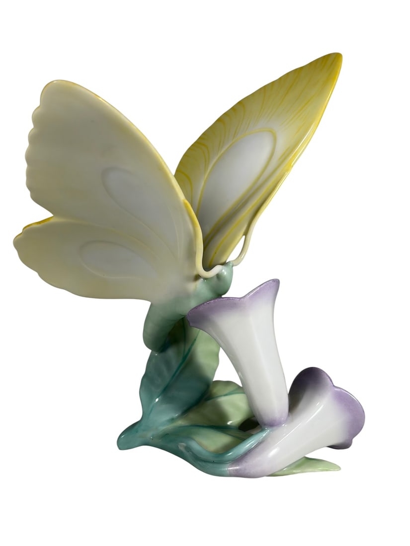 Herend Hungarian Butterfly Porcelain Figurine: Herend Hungary hand-painted porcelain butterfly and flower figurine with yellow wings and purple blossoms, marked to the underside with shield stamp.Dimensions: 5.75 X 5 X 5.75 in. Condition: Good