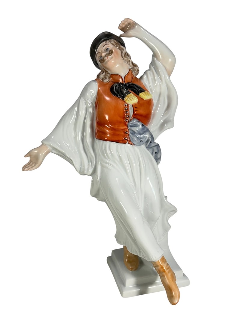 Herend Hungary Folk Dancer Porcelain Figurine: Herend Hungary porcelain figurine of a male folk dancer in traditional attire, posed mid-step with expressive detailing. Marked to the base with shield stamp. Model 5490.Dimensions: 12 X 7 X 6 in.