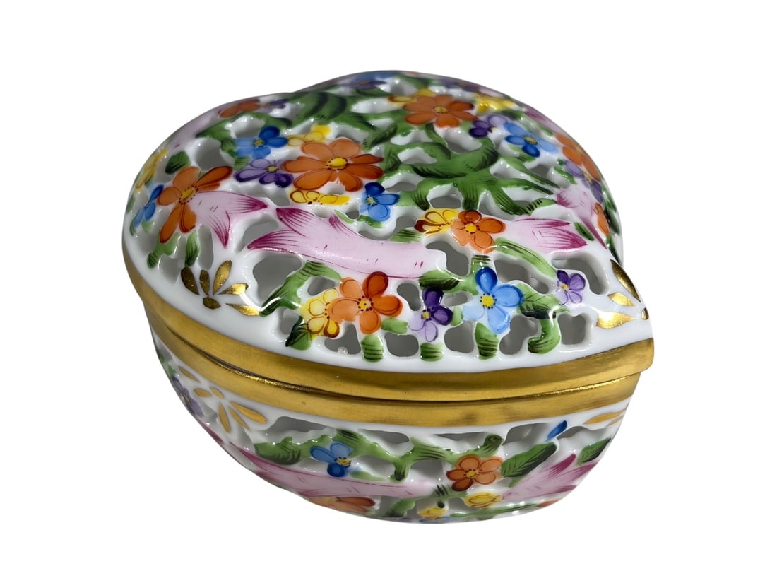 Herend Hungary Heart Open Work Porcelain Box: Herend Hungary hand-painted heart-shaped porcelain trinket box with reticulated openwork, floral decoration, and gilt trim, marked to the base. Model 6202.Dimensions: 1.75 X 2.5 X 3 in. Condition: