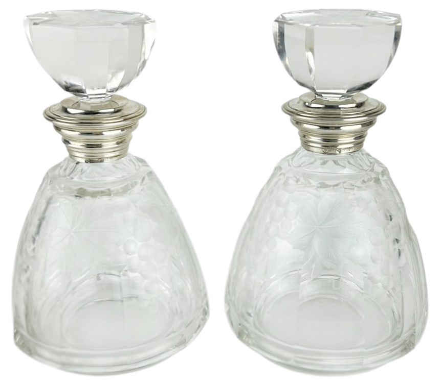Art Deco Bohemia Crystal Sterling Mount Decanters: Pair of Bohemian clear crystal art glass 20th century barware decanters with deeply cut and frosted grapevine motifs and faceted stoppers. Panel sides, the octagonal glass stoppers with matching