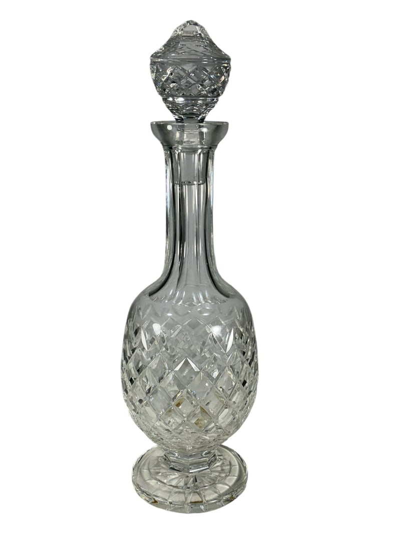 Waterford Ireland Cut Lead Crystal Decanter: Waterford Ireland cut lead crystal decanter with faceted stopper, featuring diamond-cut body and fluted neck, acid-etched Waterford mark to the base.Dimensions: 14.5 X 4.25 X 4.25 in. Condition: Good