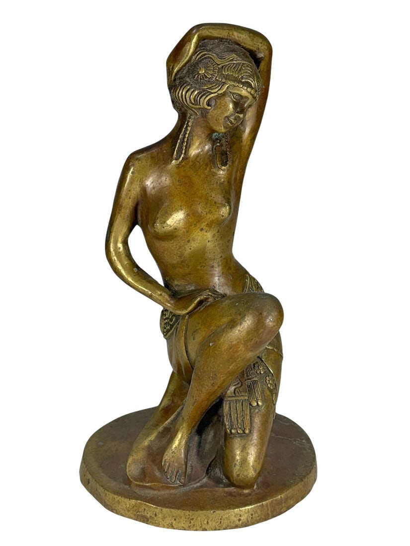 Art Deco Style Nude Woman Bronze Sculpture: Art Deco style bronze sculpture of a kneeling nude woman in an elegant pose, wearing an ornate headpiece and belt, with an integrated rounded base.Dimensions: 12.75 X 6.5 X 6.5 in. Condition: Good