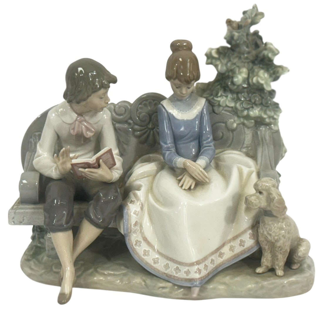 Lladro Poetry of Love Porcelain Figurine No. 5442: Lladro Spanish porcelain figurine titled 'Poetry of Love' model number 5442. This piece depicts a tender moment between a young man reading poetry and a young woman seated beside him on a decorative