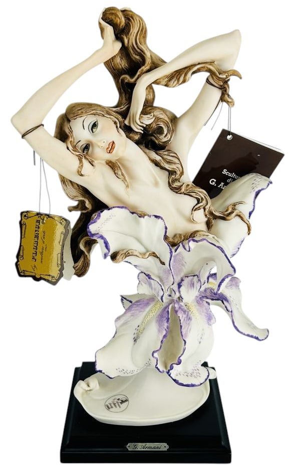 Giuseppe Armani Awakening #591C Figurine w/ Box: Giuseppe Armani (Italian, 1935 - 2006), hand painted figurine. Titled Awakening. Model number 591C. Depicting a reclining female form with iris bloom base, mounted on a wood plinth with the G. Armani