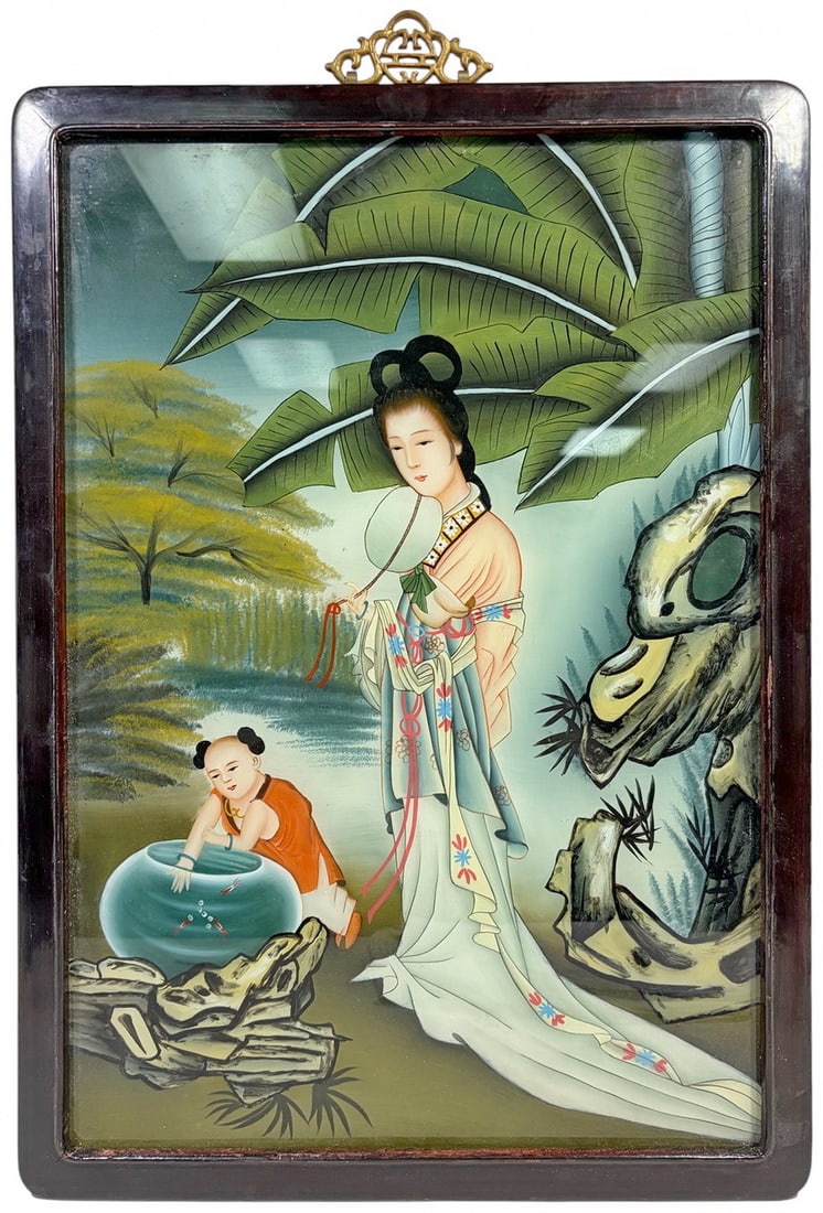 Chinese Export Framed Reverse Glass Painting: Chinese Export reverse glass painting depicting a lady holding a fan with a child beside a fishbowl, set within a serene garden landscape and housed in a hardwood frame.Work Size: 20.75 x 14