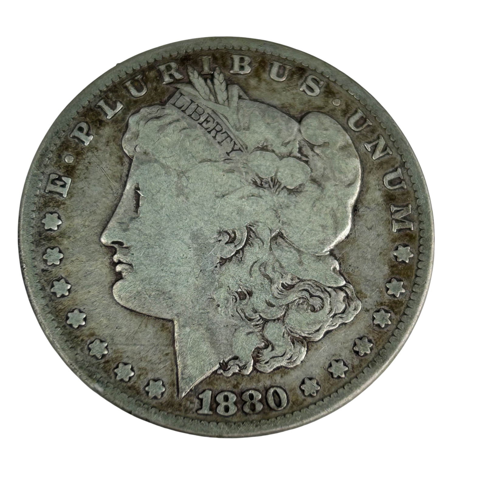 United States 1880 Morgan Silver Dollar Coin: United States 1880 Morgan Silver Dollar designed by George T. Morgan. The obverse shows Liberty in profile with the motto E Pluribus Unum, and the reverse features a heraldic eagle with the motto In G