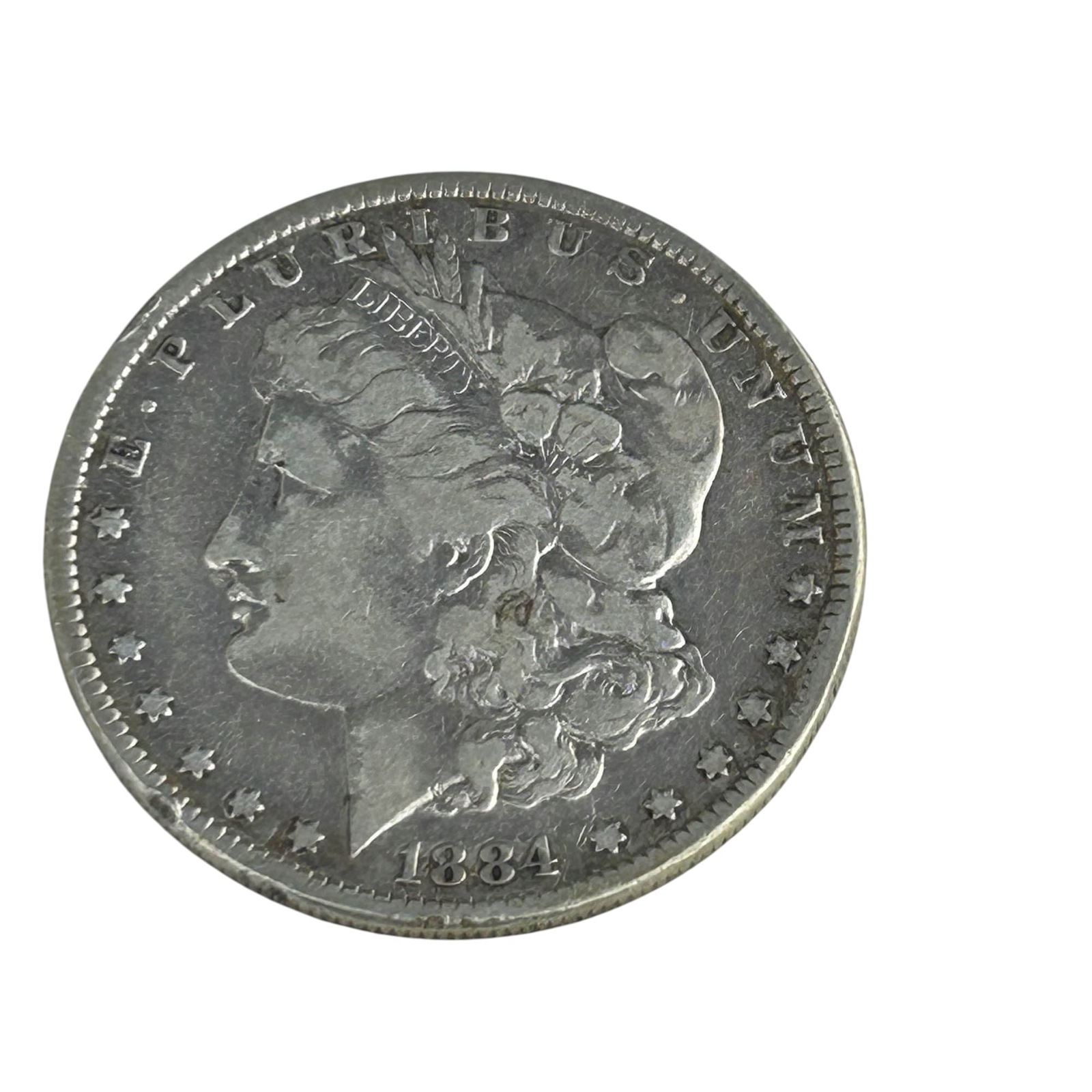 United States 1884 Morgan Silver Dollar Coin: United States 1884 Morgan Silver Dollar designed by George T. Morgan. Obverse features Liberty in profile with the motto E Pluribus Unum, and the reverse displays a heraldic eagle with outstretched wi