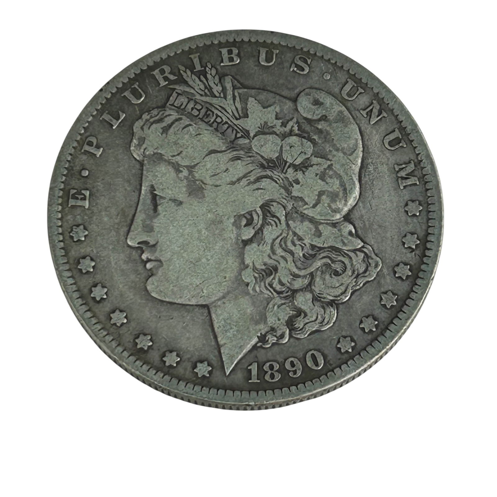 United States 1890 O Morgan Silver Dollar Coin: United States 1890 Morgan Silver Dollar struck in New Orleans. Designed by George T. Morgan, with Liberty in profile on the obverse and a heraldic eagle on the reverse. The "O" mintmark is visible bel
