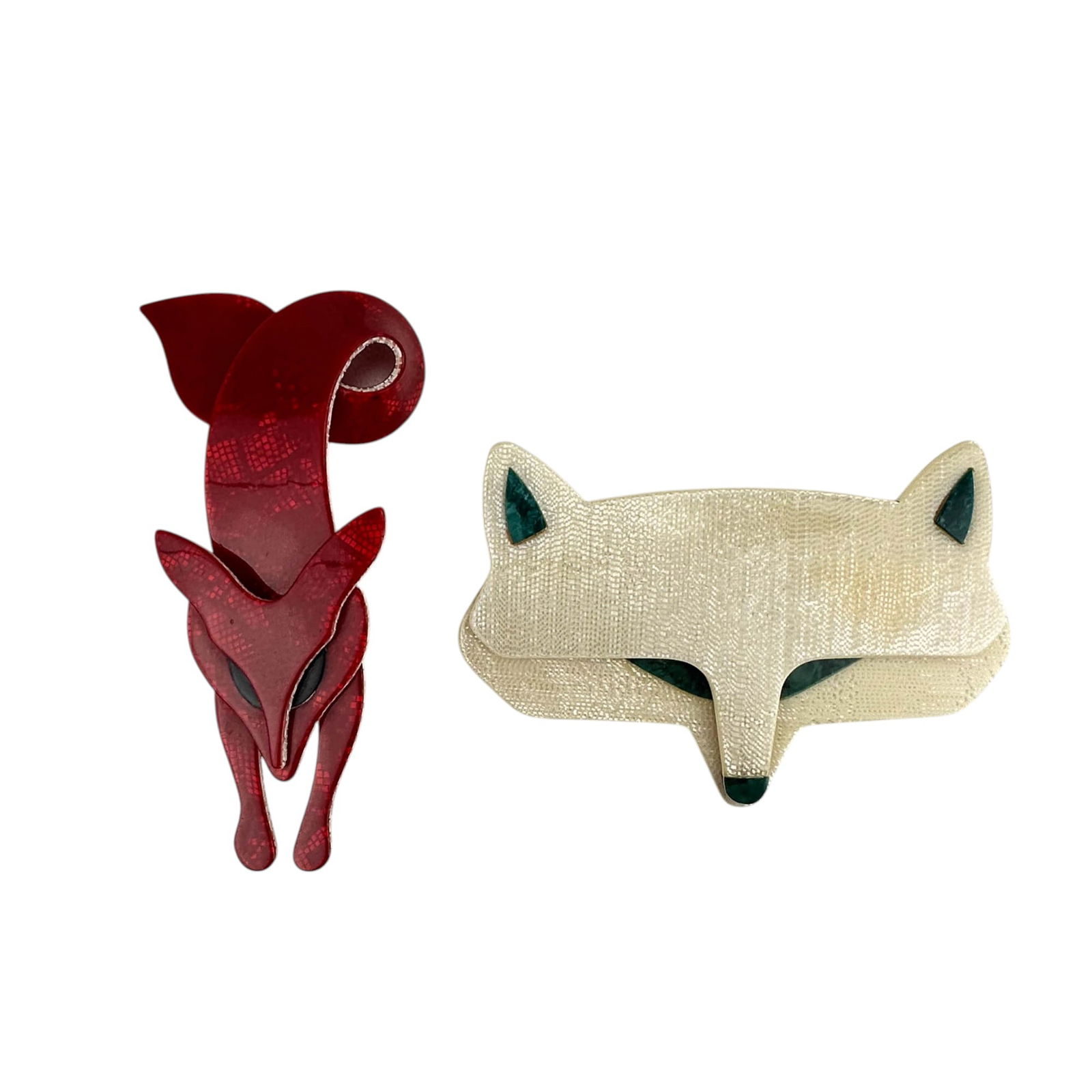 Lea Stein b.1936 Celluloid Red & White Fox Pins: Lea Stein (French, born 1936), artist and accessory maker known for her compressed plastic brooches, bracelets and buttons. One features a red curled fox with a scale textured surface, the other is a