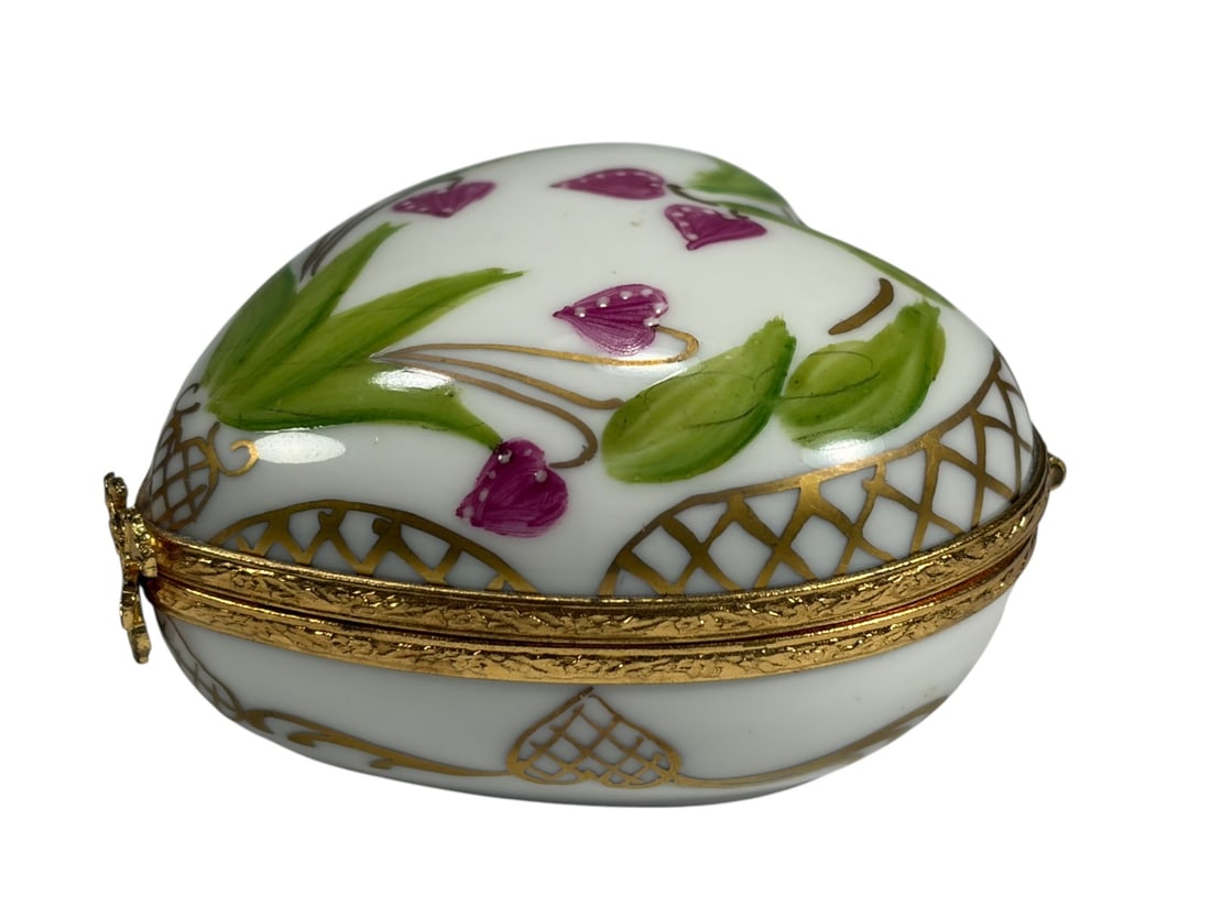 Limoges France Hand-Painted Heart Trinket Box: Limoges France porcelain heart shaped trinket box, hand painted with purple floral motifs and green leaves, accented with gilt. White body decorated with gold lattice and scrollwork, with hinged gilt