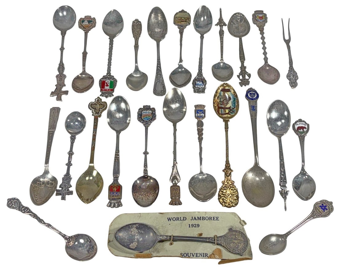 1929 World Jamboree & Others Souvenir Spoons 25pcs: Mixed group of souvenir spoons and one fork including a 1929 World Jamboree souvenir spoon with original paper card, plus assorted international and regional souvenir examples with enameled crests