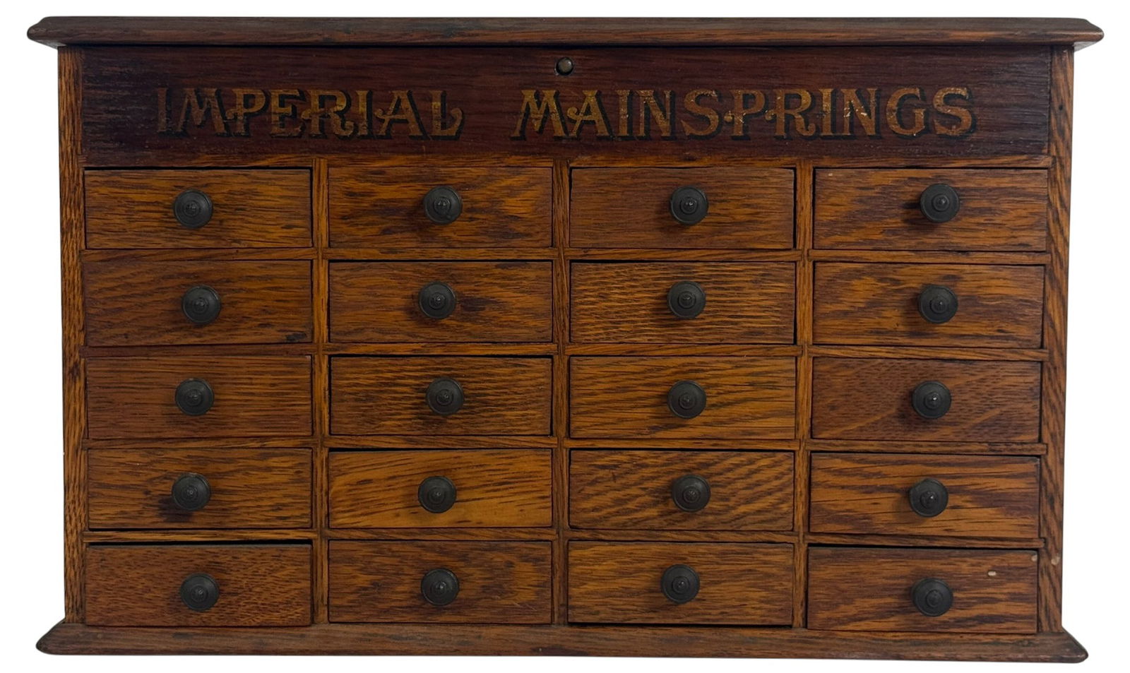 Antique Green Bros. Oak Watchmakers Parts Cabinet: Early 20th century oak watchmakers parts cabinet with 24 small drawers and a lift-top compartment. The front is stenciled in black and gold with the words 'IMPERIAL MAINSPRINGS', a known brand for tim