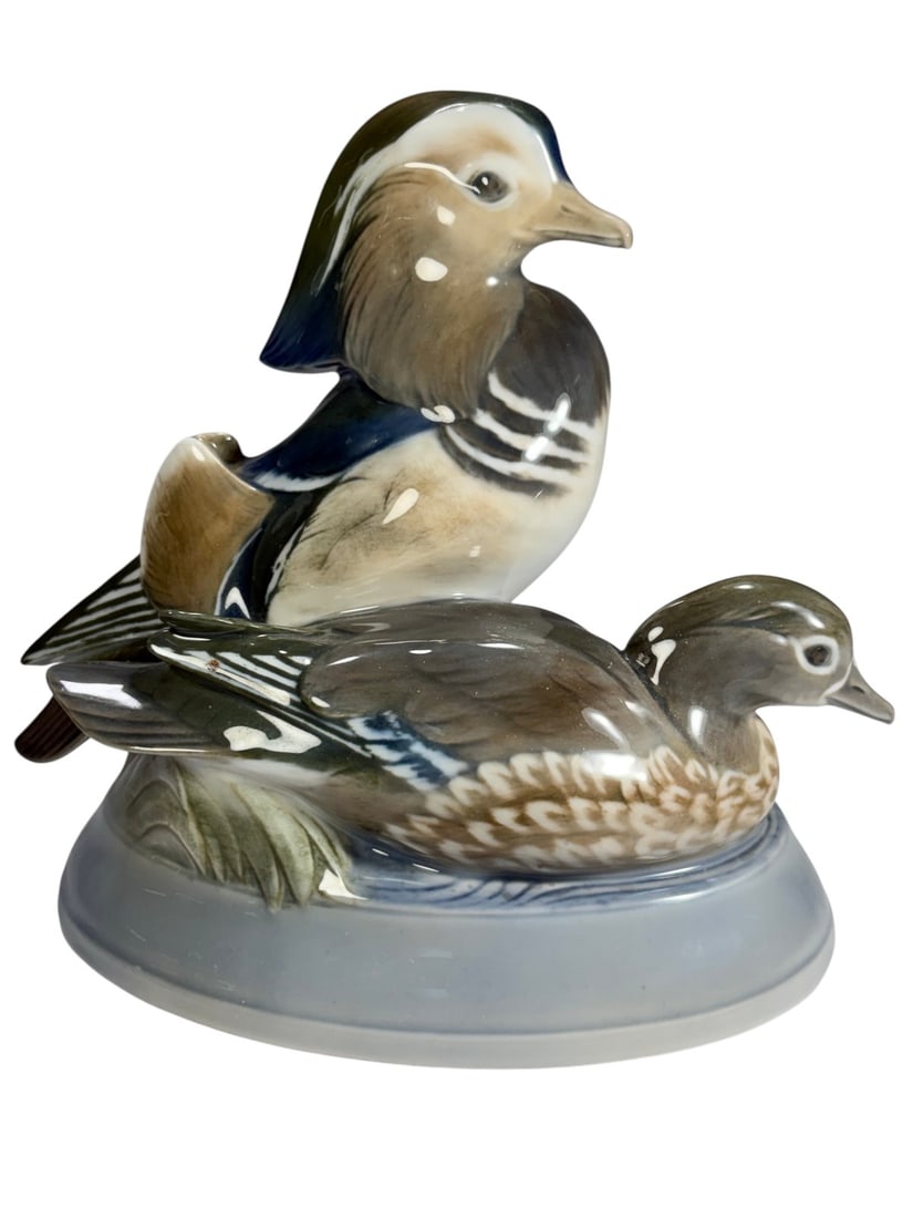 Royal Copenhagen Mandarin Ducks Figurine by Herold: Royal Copenhagen porcelain figurine by Peter Herold depicting a pair of Mandarin ducks, finely modeled and hand painted in naturalistic tones of green, blue, brown, and cream, set on a soft blue glaze