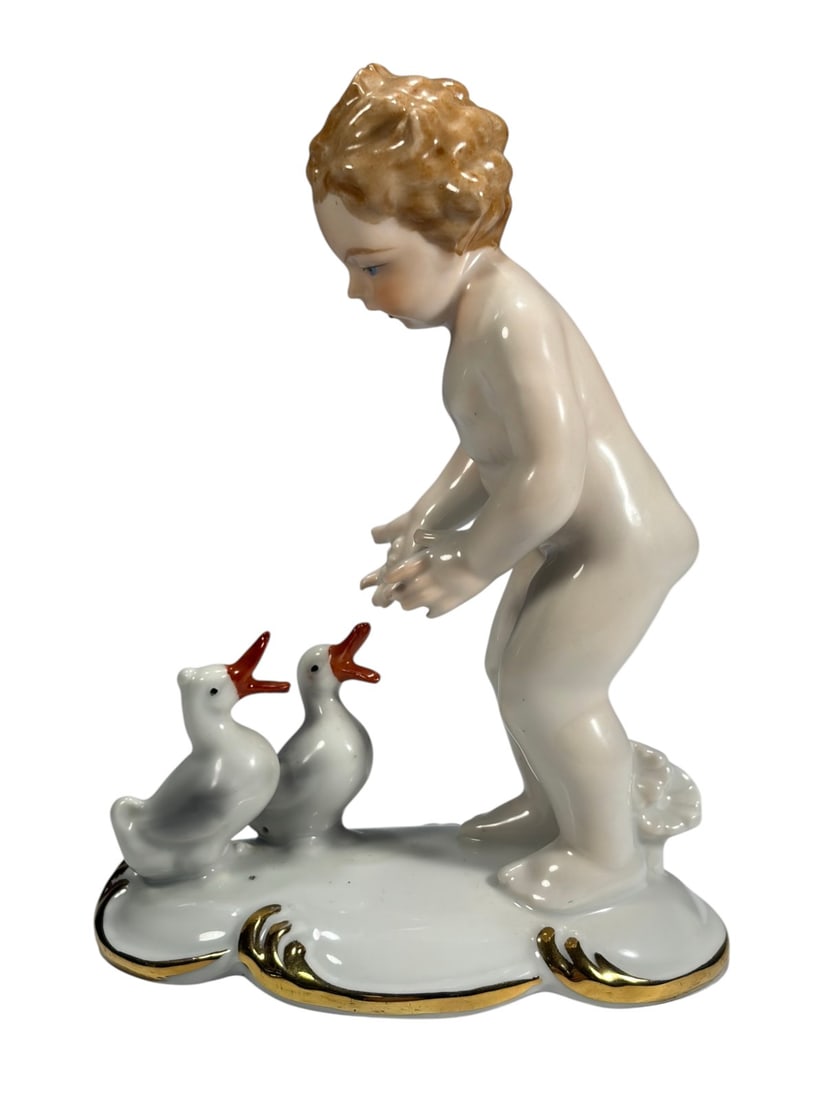 Gerold & Co Tettau Boy Feeding Ducks Porcelain Fig: Gerold and Co Tettau Bavaria porcelain figurine of a nude boy feeding two ducks. Curly light brown hair, hands extended as the ducks look up with orange beaks, on shaped white base with gilt trim and