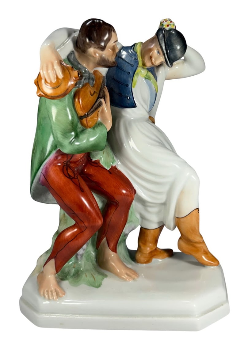 Herend Hungary Dancing Men Porcelain Figurine 9": Herend Hungary hand painted porcelain Dancing Men figurine group. Two male figures in traditional dress, one seated on a tree stump playing violin, the other leaning back mid dance, finely detailed vi