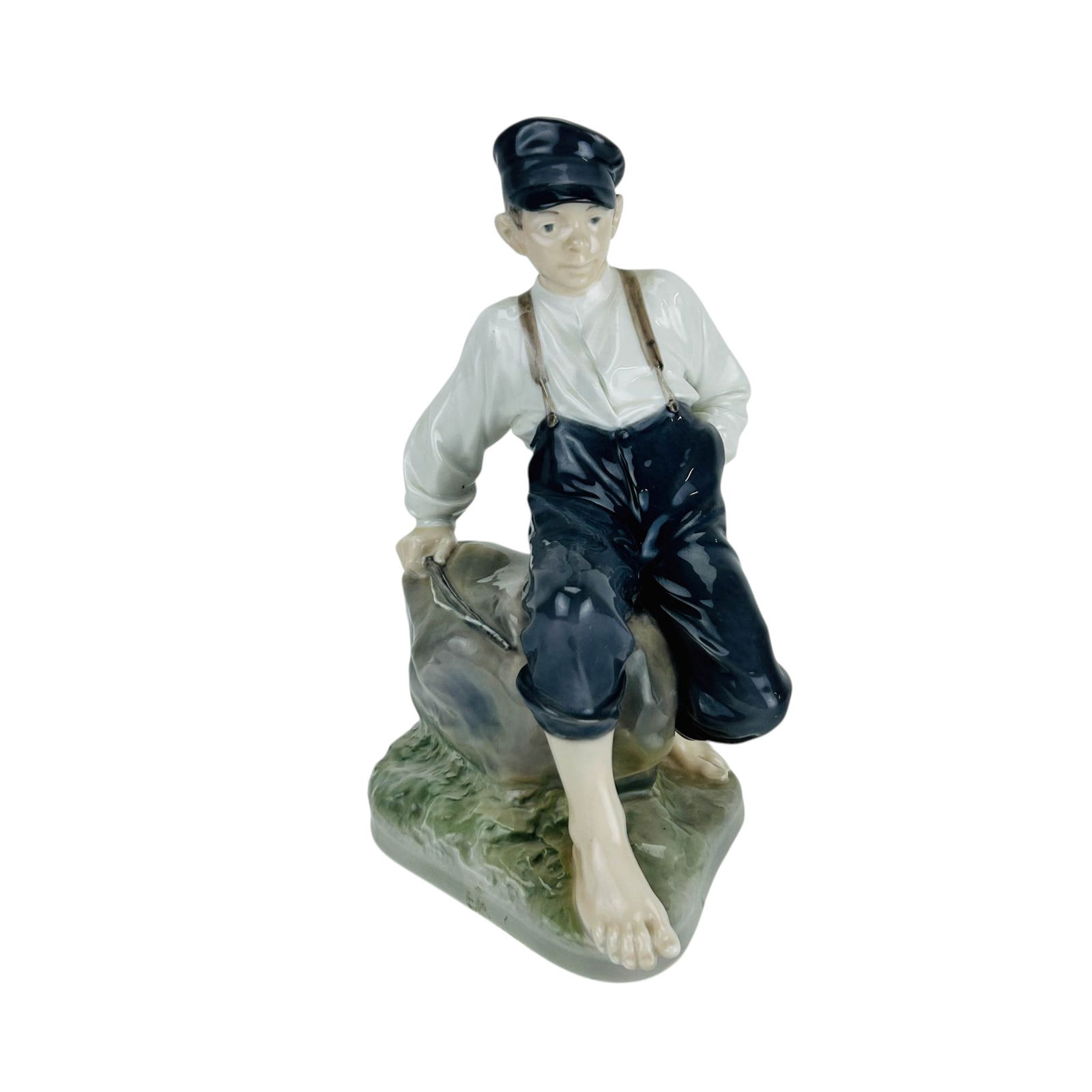 Royal Copenhagen Shepherd Boy on Rock #1659 12.5": Royal Copenhagen Denmark porcelain figurine titled Shepherd Boy on Rock model number 1659. Designed by Christian Thomsen (Danish, 1860-1921). Features a boy seated on a rock dressed in traditional wor