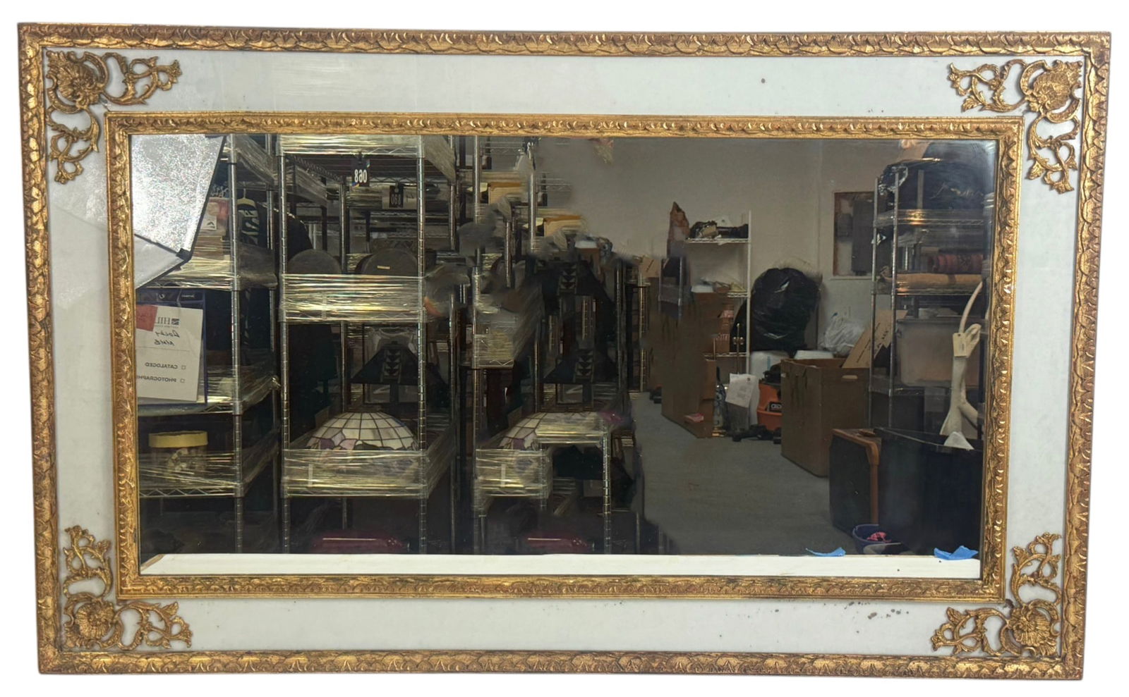 Vintage Gilt Framed Wall Mirror w/ Floral Borders: Vintage wall mirror featuring a rectangular beveled mirror plate set within a decorative gilt frame. The frame includes pale panels with applied gilt floral corner ornaments and a patterned inner bord