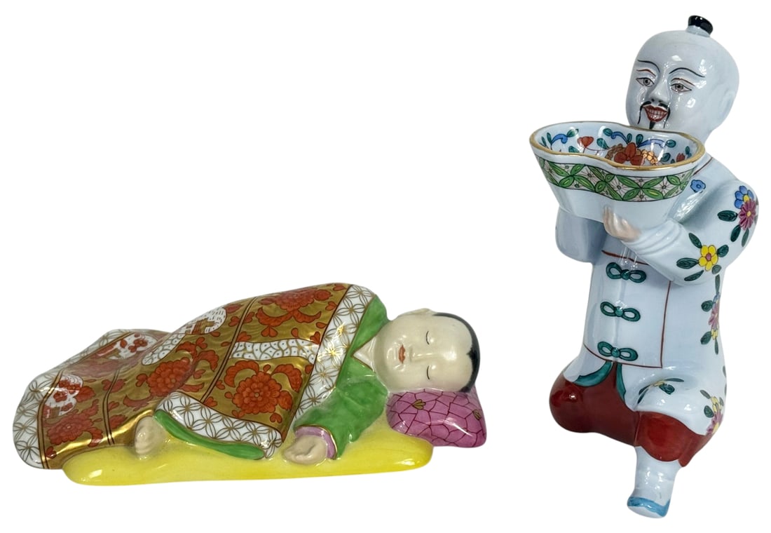 Herend Hungarian Porcelain Figurines 2pc LOT: Lot of two Herend Hungarian porcelain figurines, hand-painted in vibrant polychrome enamel decoration. One figure depicts a kneeling man holding a floral-decorated bowl; and the other is a figural rec