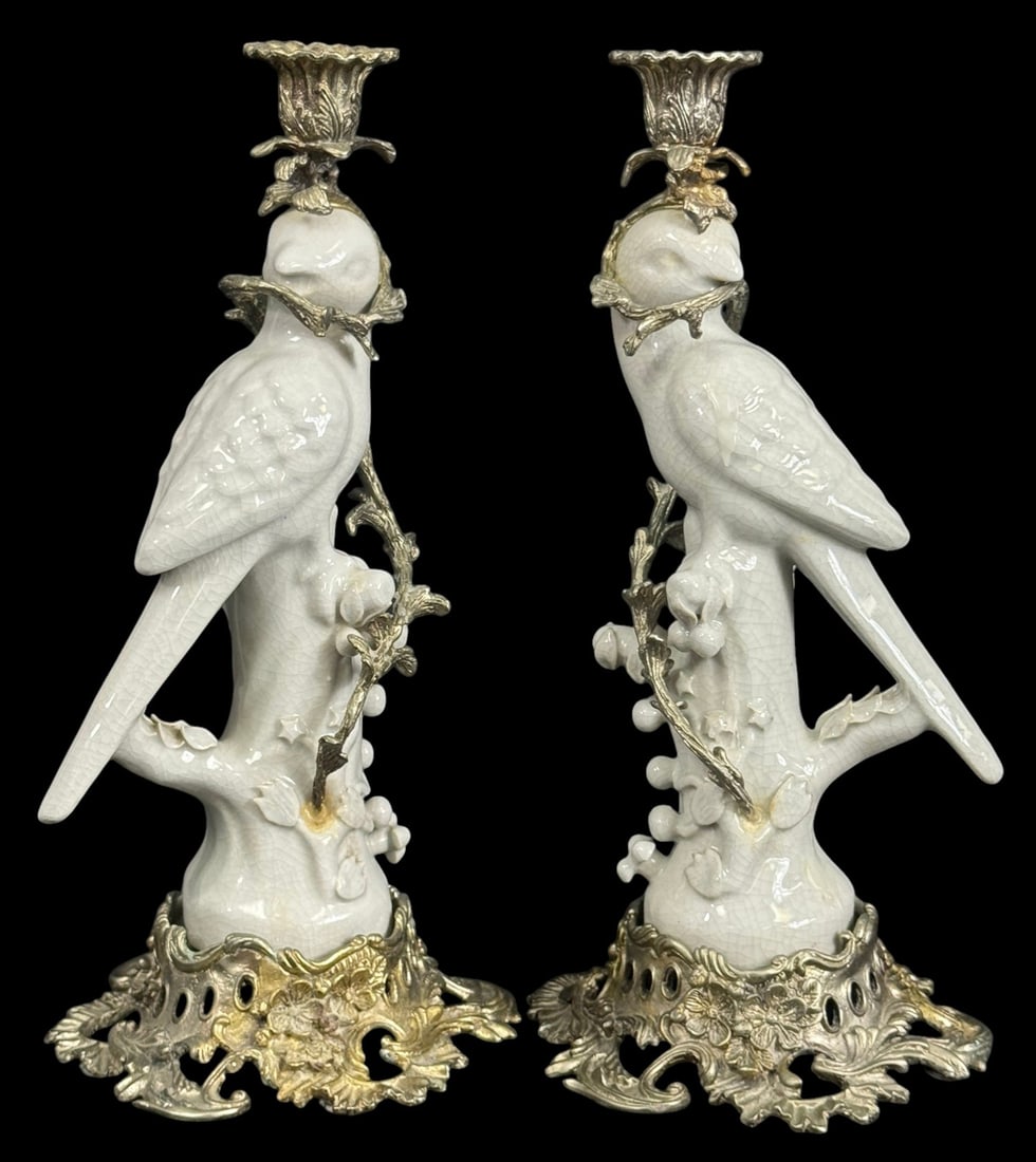 Italian White Porcelain Parrot Candlestick Holders: figural candlesticks featuring finely modeled white porcelain parrots perched on flowering branches, mounted on ornate silver plated bases with floral and scrollwork motifs. Each bird supports a singl