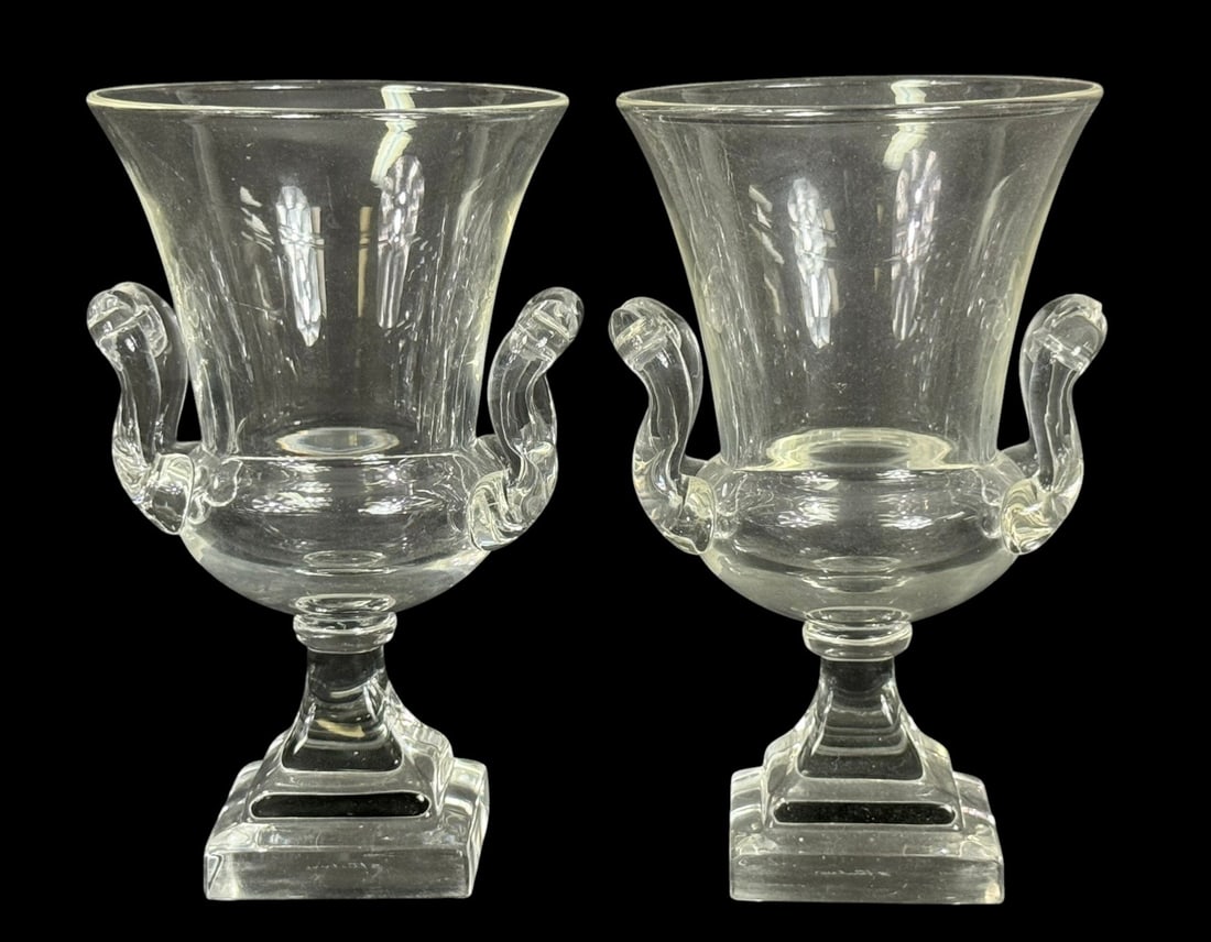 Pair of Steuben Crystal Urn Vases w/ Swan Handles: Pair of Steuben crystal urn-form vases, each featuring hand-applied swan-form handles and set on square pedestal bases. Crafted in clear lead crystal with classic neoclassical styling and fine clarity