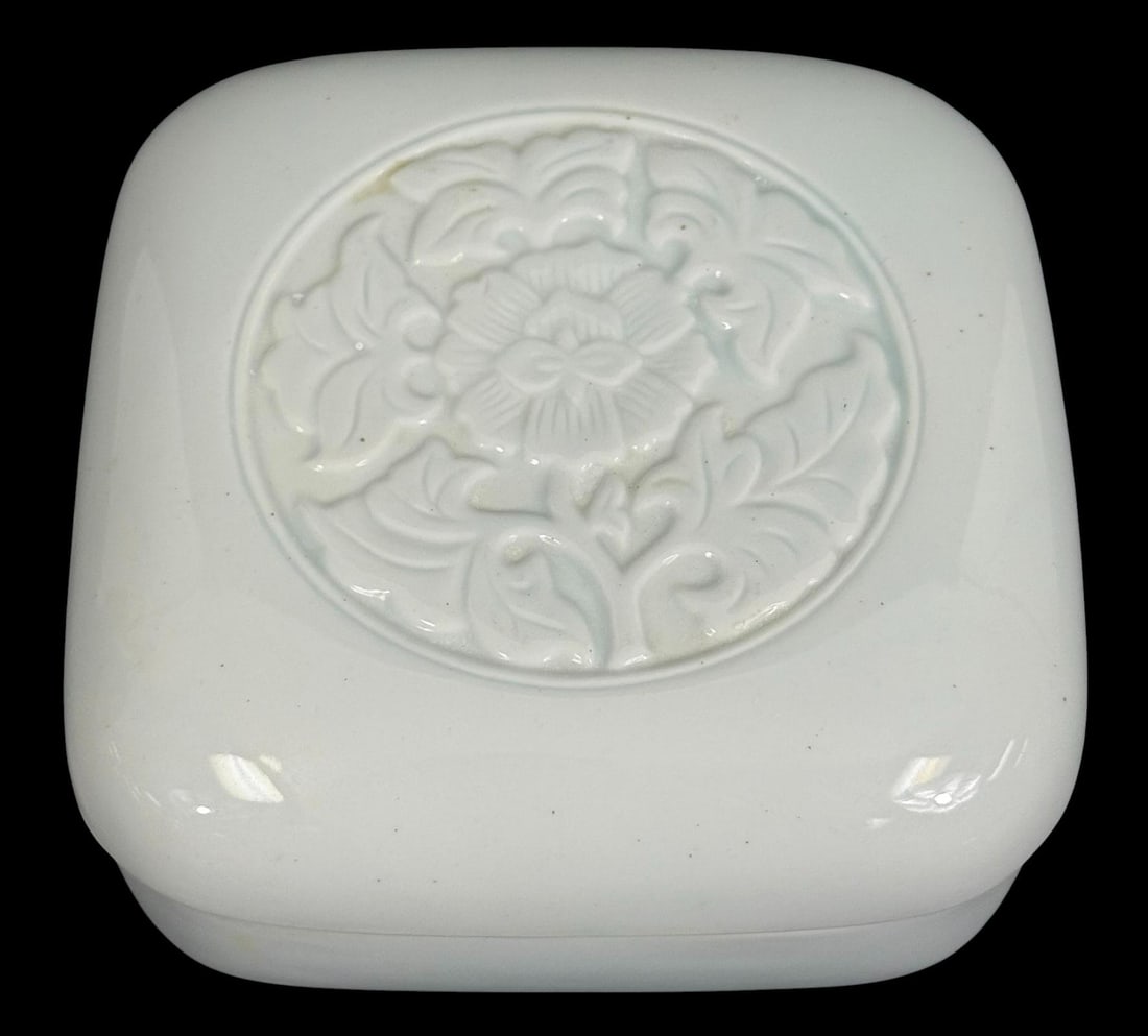 Tiffany & Co. 1979 Porcelain Lidded Trinket Box: Tiffany & Co. porcelain lidded box featuring a square form with rounded edges and a soft celadon glaze, with a raised floral medallion motif centered on the lid. The delicate relief pattern evokes cla