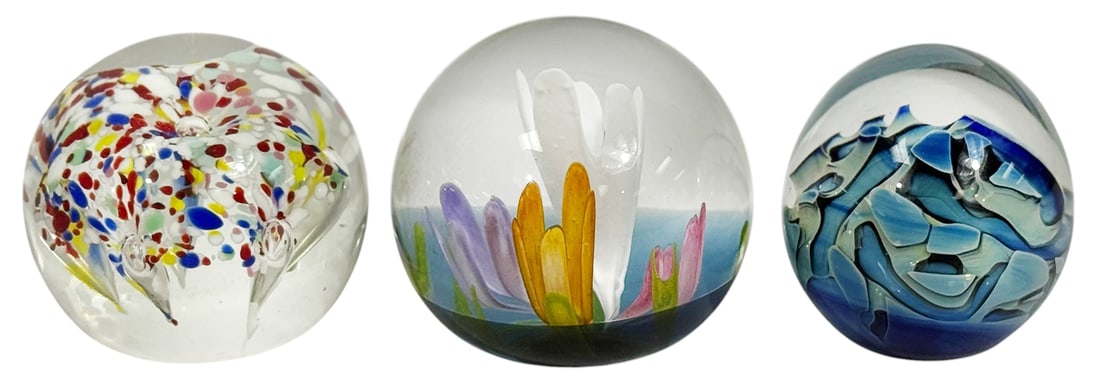 1980s Signed Studio Art Glass Paperweights 3pc LOT: Lot of three art glass paperweights with controlled bubble and floral designs. One example is signed Eickholt 1987 and another marked Caithness Symphony Scotland 736/750. The third paperweight feature